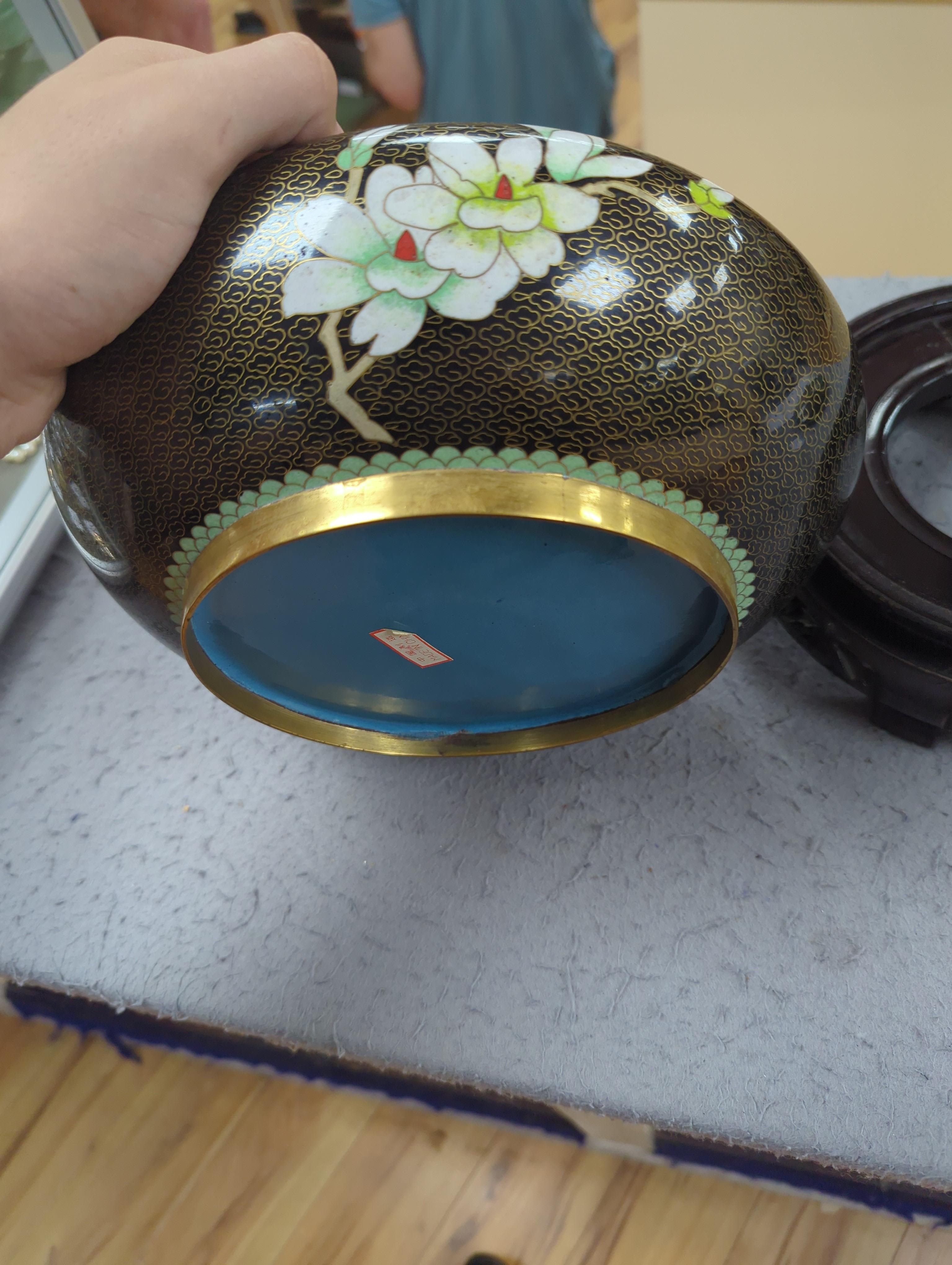 A Chinese cloisonné enamel three footed vase and cover together with a censer and cover, each raised on hardwood stands, the largest 26cm in diameter